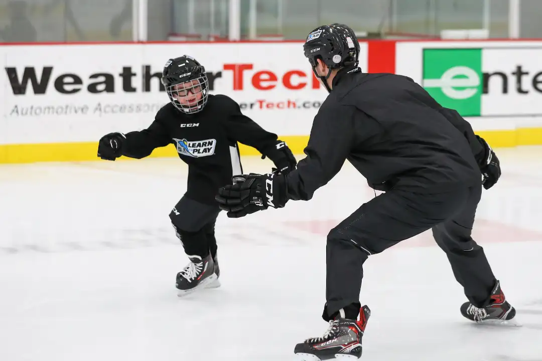 Youth hockey player training with adult instructor