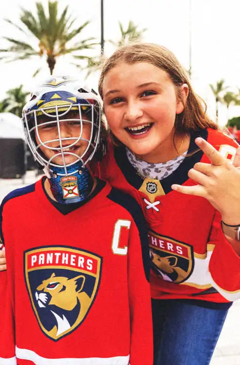 Two kids smiling with florida panthers jerseys