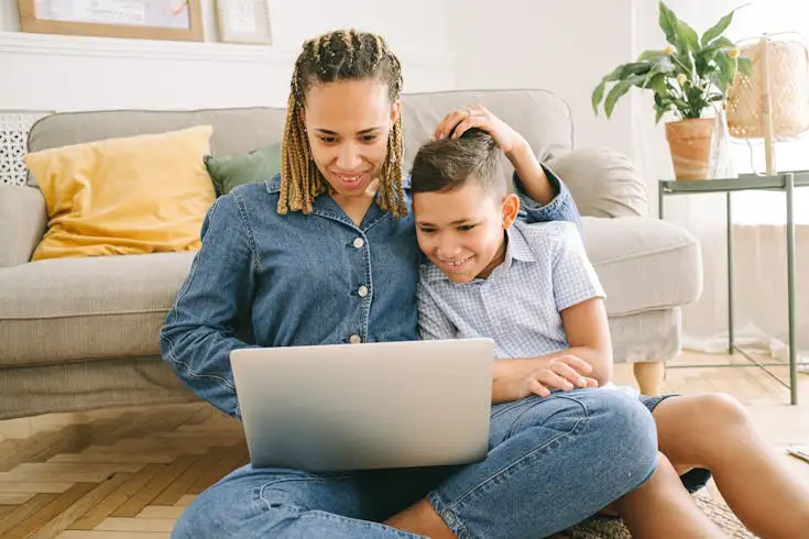 Stock photo of parent using laptop with child
